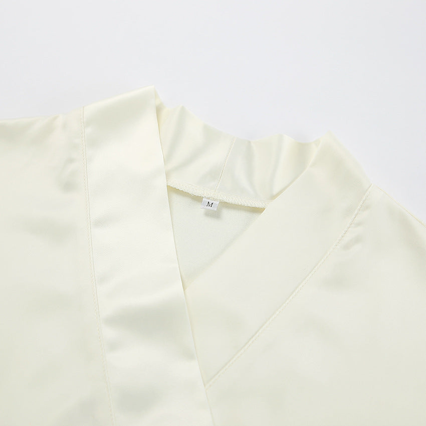Dame Satin- jumpsuit med elegant omslag design og svajende kant Stilla