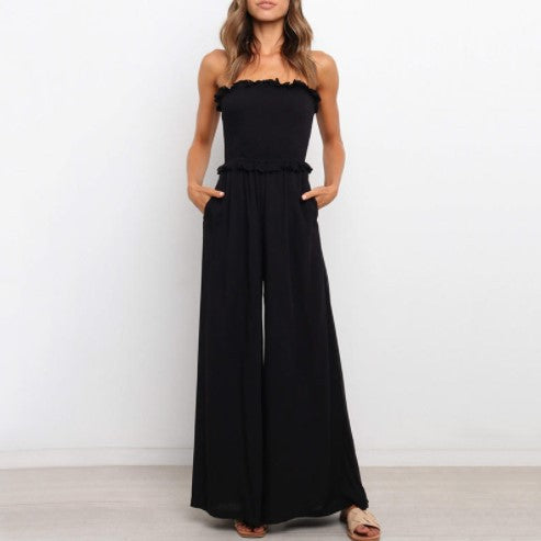 Dame bærer løs jumpsuit med bred ben og flæse kant Stilla